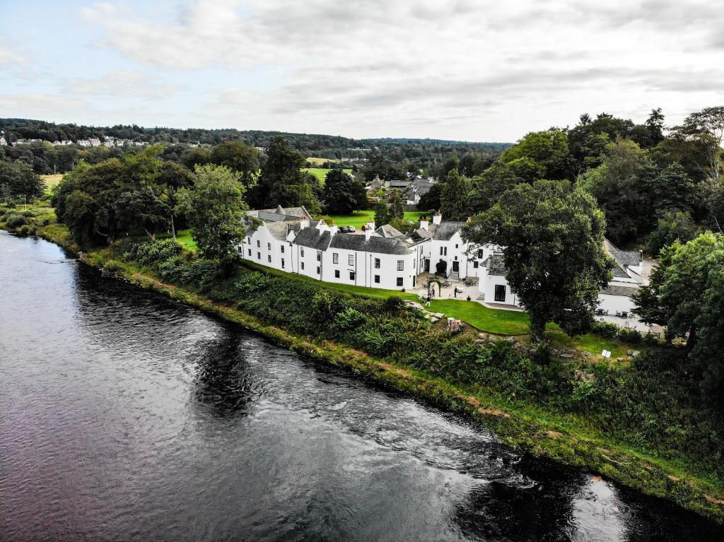 an aerial view of a large house next to a river at Maryculter House in Maryculter