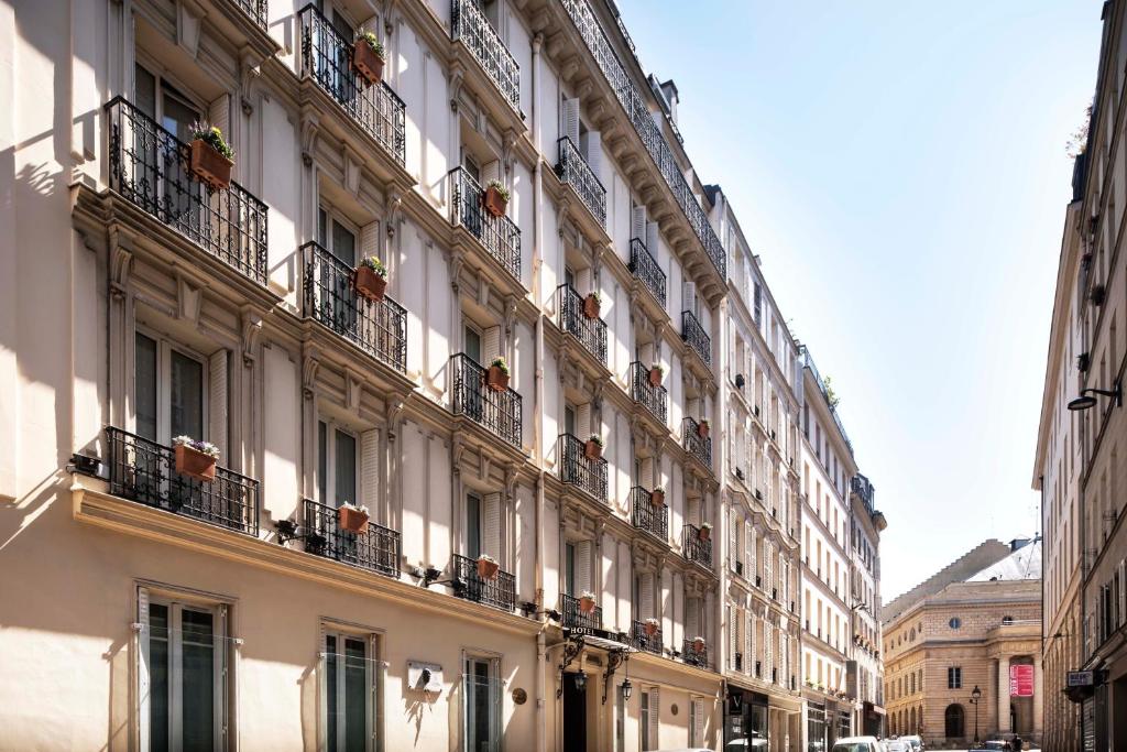 パリにあるグランド ホテル デ バルコンの通りに面した白い大きな建物