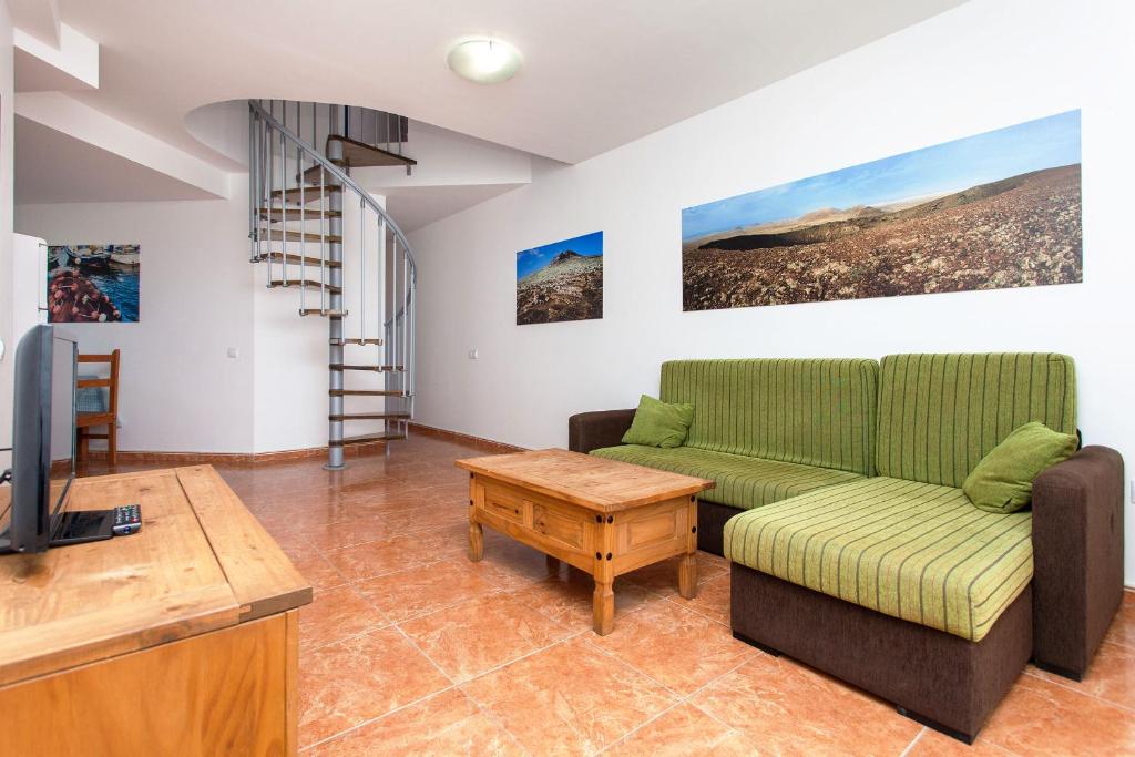a living room with a couch and a tv at TAO El Cotillo in El Cotillo