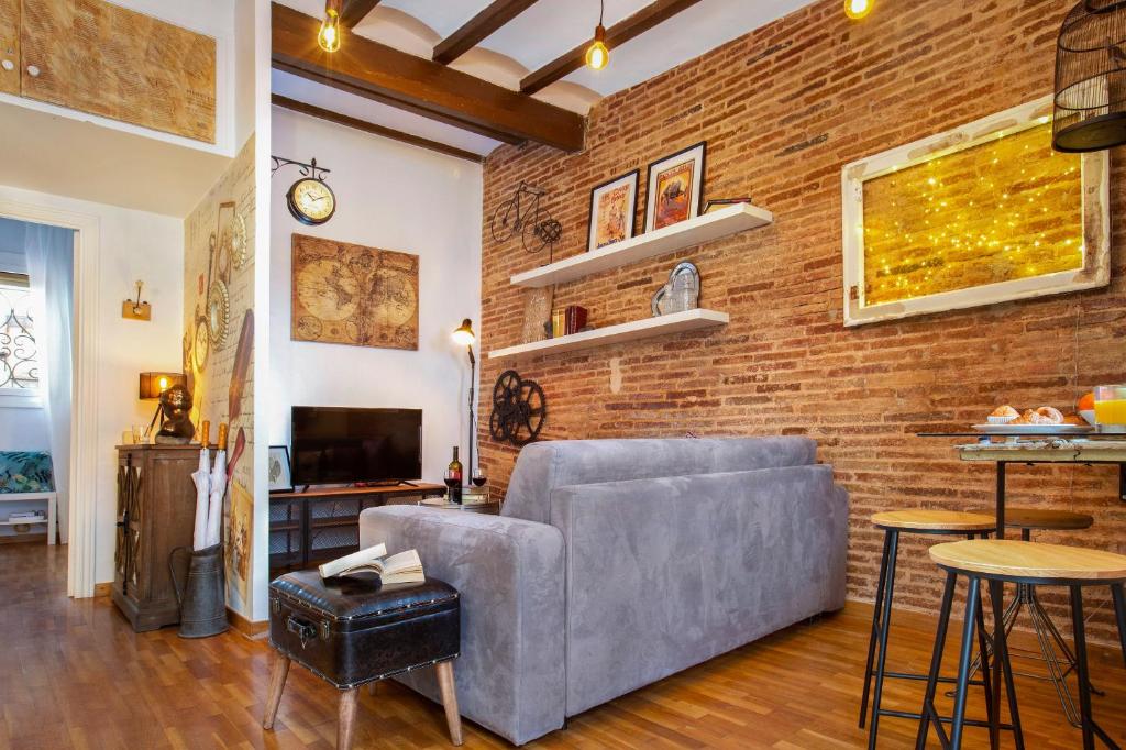 a living room with a couch and a brick wall at Stay U-nique Apartments Ramón y Cajal in Barcelona