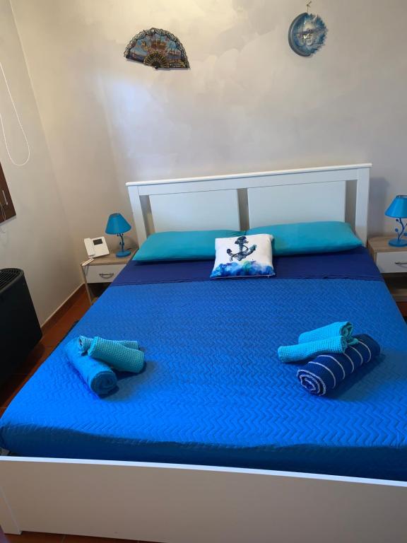 un letto con lenzuola blu e due cuscini sopra di Azul - privacy tranquillità natura e mare a Rosolina Mare