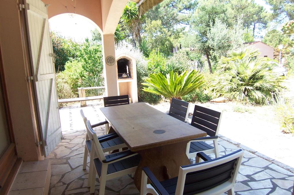 une table et des chaises en bois sur une terrasse dans l'établissement Andre, à Porto-Vecchio