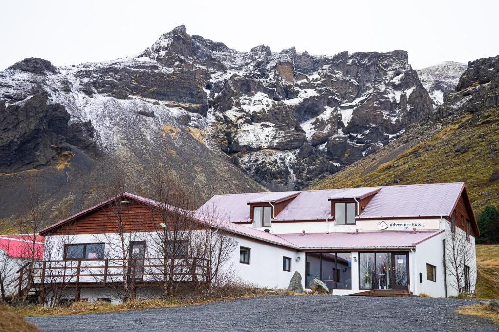 een wit gebouw met een berg op de achtergrond bij Adventure Hotel Hof in Hof