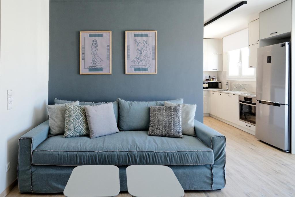 雅典的住宿－Odyssey Residence，客厅设有蓝色沙发,配有厨房
