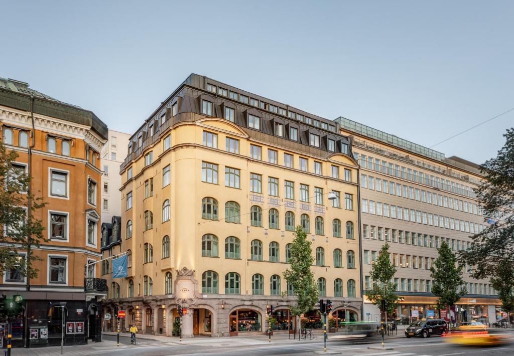 un gran edificio amarillo en una calle de la ciudad en Miss Clara by Nobis, Stockholm, a Member of Design Hotels™, en Estocolmo