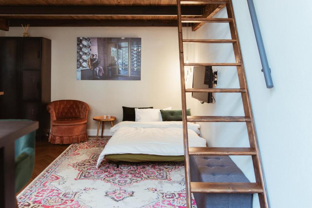 um quarto com uma escada ao lado de uma cama em LoftBrücke, Apartment am Platz der Luftbrücke em Berlim