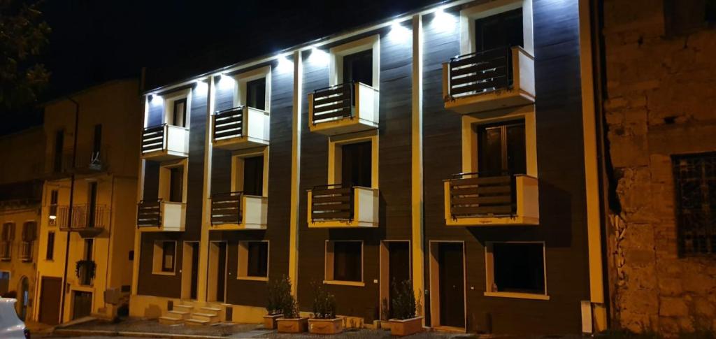 a building with balconies on the side of it at night at La Casina di Montagna by Dimorra in Rivisondoli