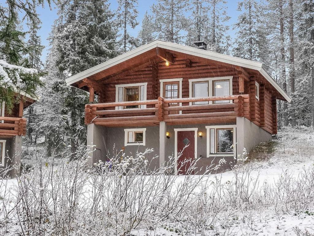 a log cabin in the snow with trees at Holiday Home Oloskammi 5 by Interhome in Muonio
