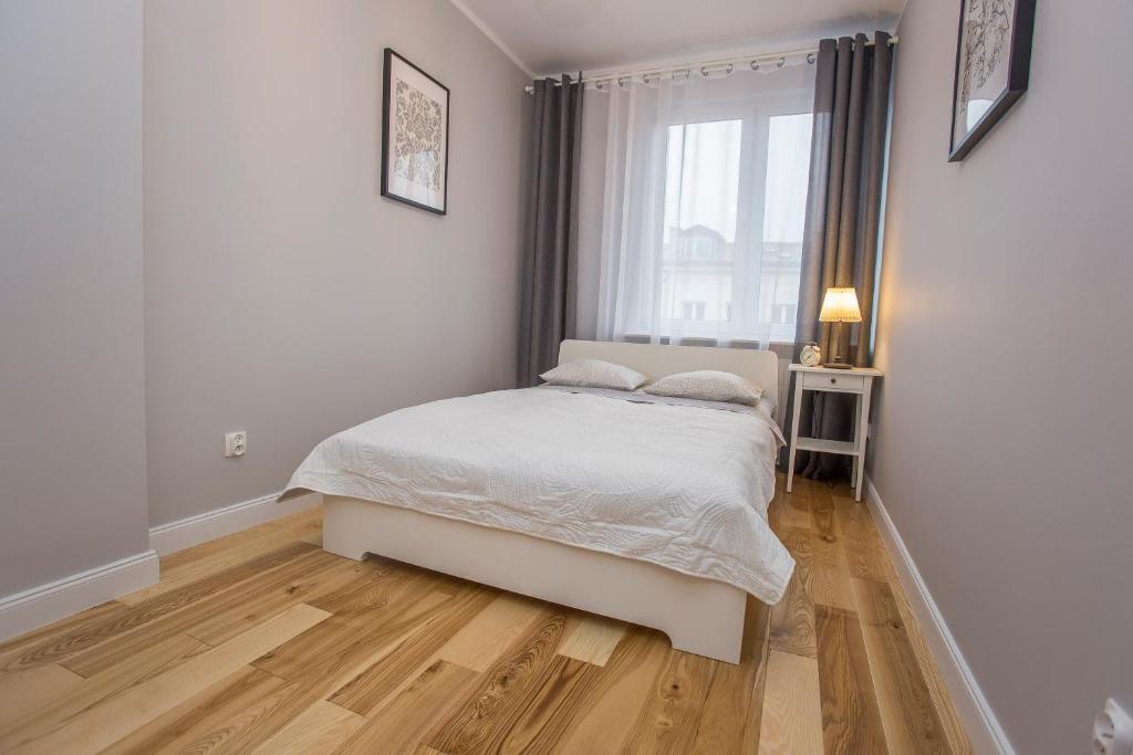 una camera bianca con un letto e una finestra di CR Apartament w sercu miasta Lipowa 1 a Białystok