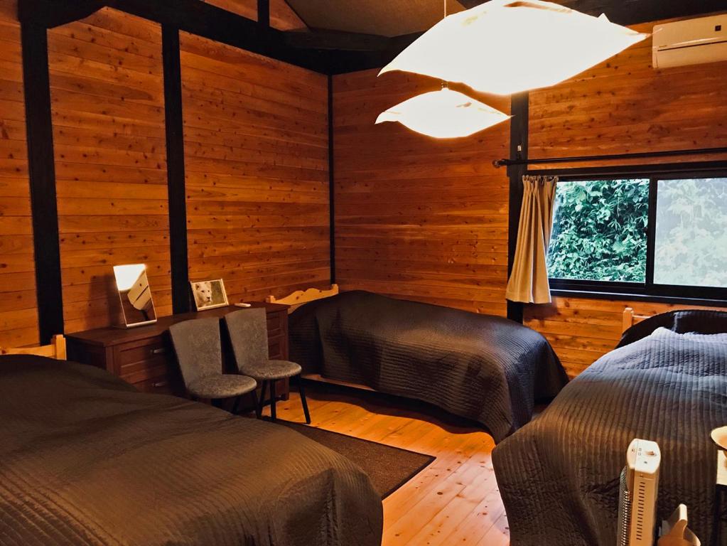a bedroom with two beds and a window at Villa yamato in Kumamoto