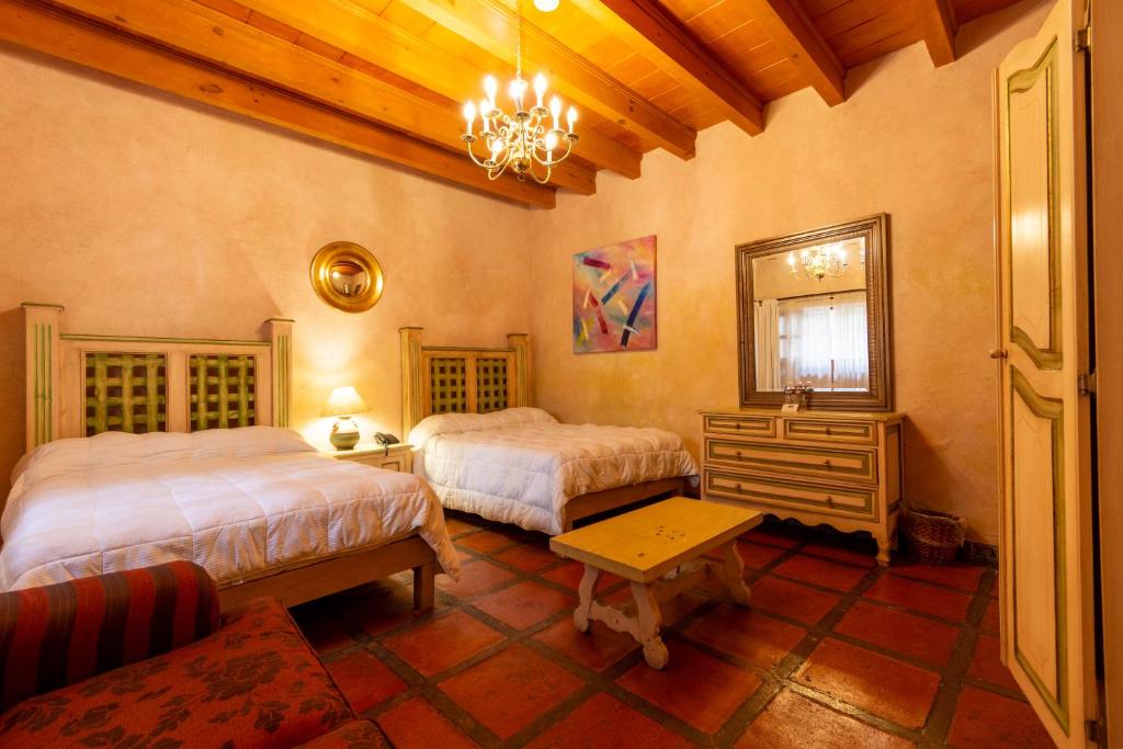a bedroom with two beds and a mirror at Casa Magica in Guanajuato