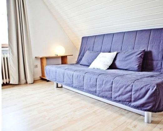 a large purple couch in a room with at Picklapp Apartments in Hamburg