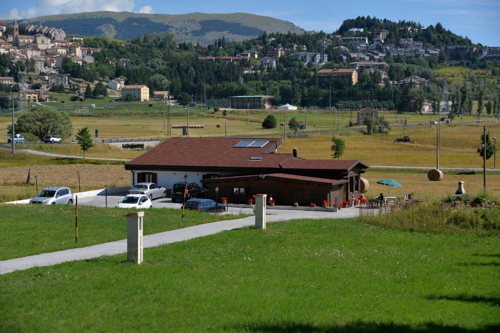 un bâtiment dans un champ à côté d'une pelouse dans l'établissement Rifugio Le Chevalier, à Roccaraso