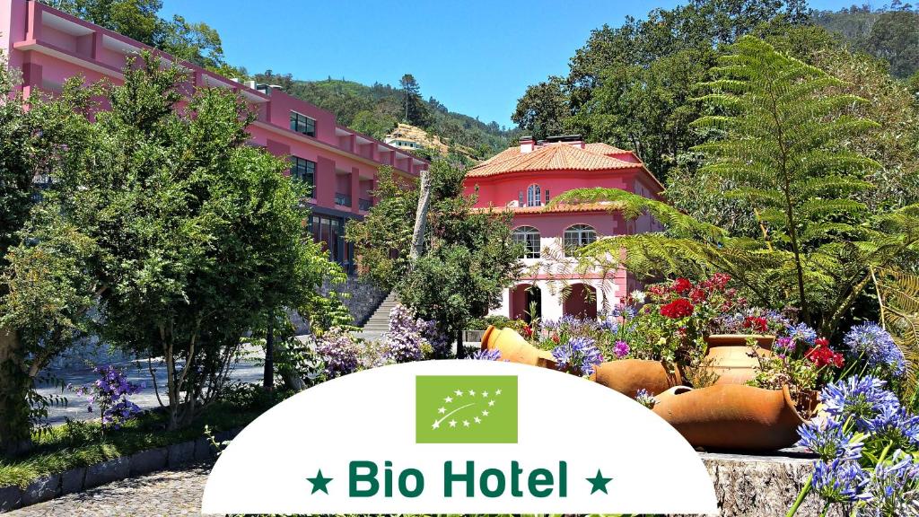 un edificio con un cartel frente a un jardín en BIO Hotel - Hotel Quinta da Serra en Estreito de Câmara de Lobos