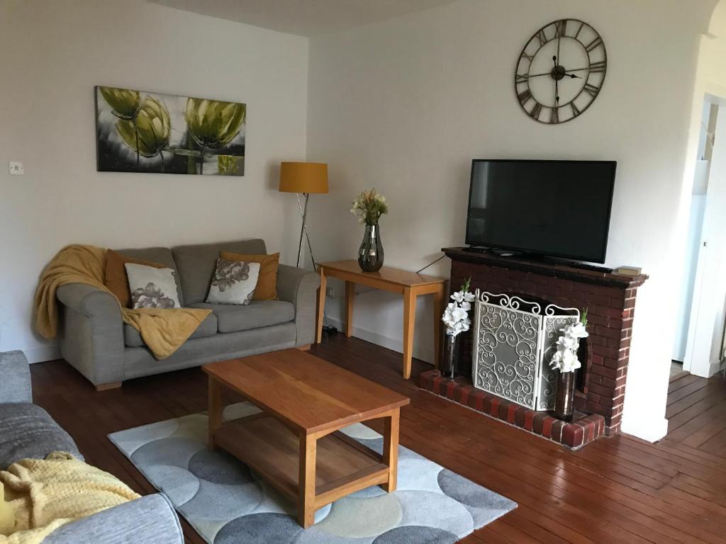 a living room with a couch and a flat screen tv at You deserve a staycation on the Firth of Clyde in Helensburgh