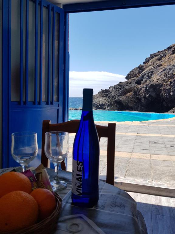 uma garrafa de vinho sentada numa mesa com um cesto de laranjas em Sueño de Mar em Güímar