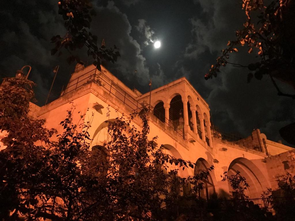 een kerk 's nachts met de maan in de lucht bij Melekler Evi Cave Hotel in Urgup