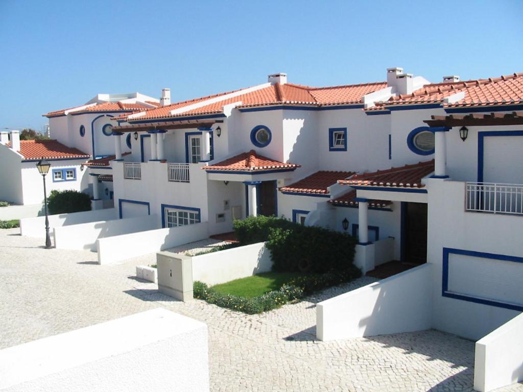uma fila de casas brancas com telhados vermelhos em Holiday Home Praia del Rey Golf by Interhome em Praia del Rei