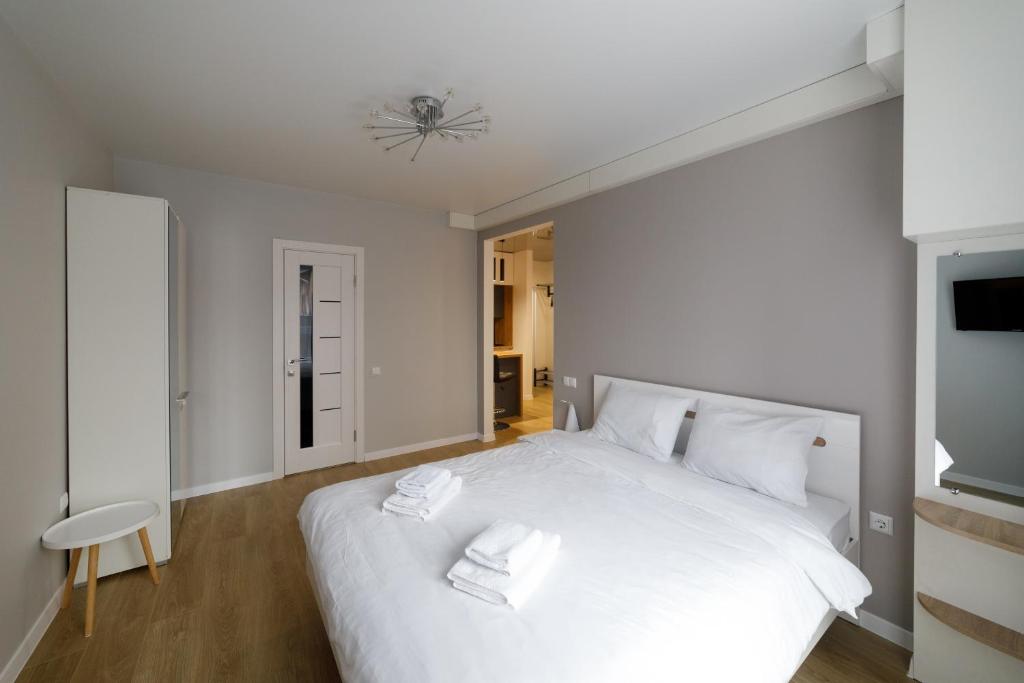 a bedroom with a large white bed with white pillows at Pure Apartments in Lviv