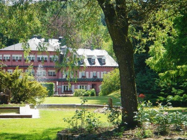 un gran edificio rojo en medio de un parque en Auberge De La Gaichel, en Gaichel