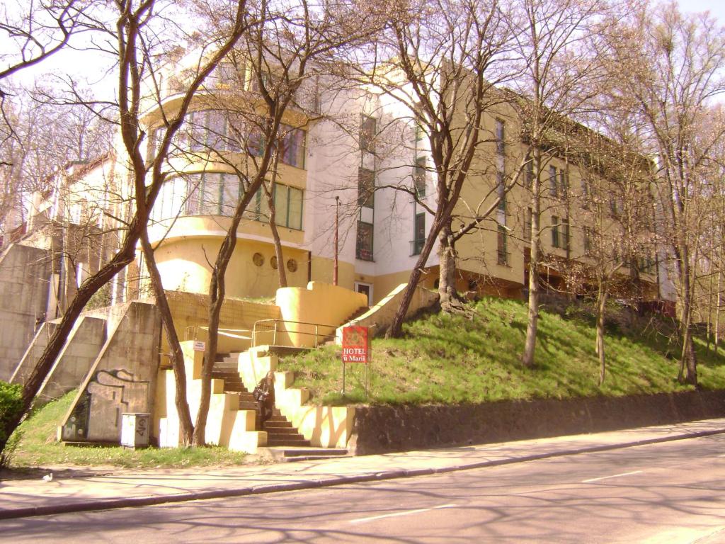 ゴジュフ・ヴィエルコポルスキにあるU Marii Hotelの階段と木が目の前に建つ建物