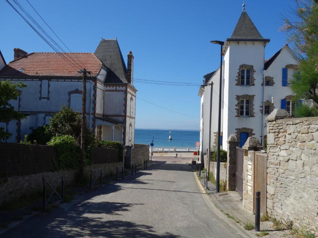 a street with houses and the ocean in the background at Apartment Les Terrasses de la Plage-2 by Interhome in Quiberon