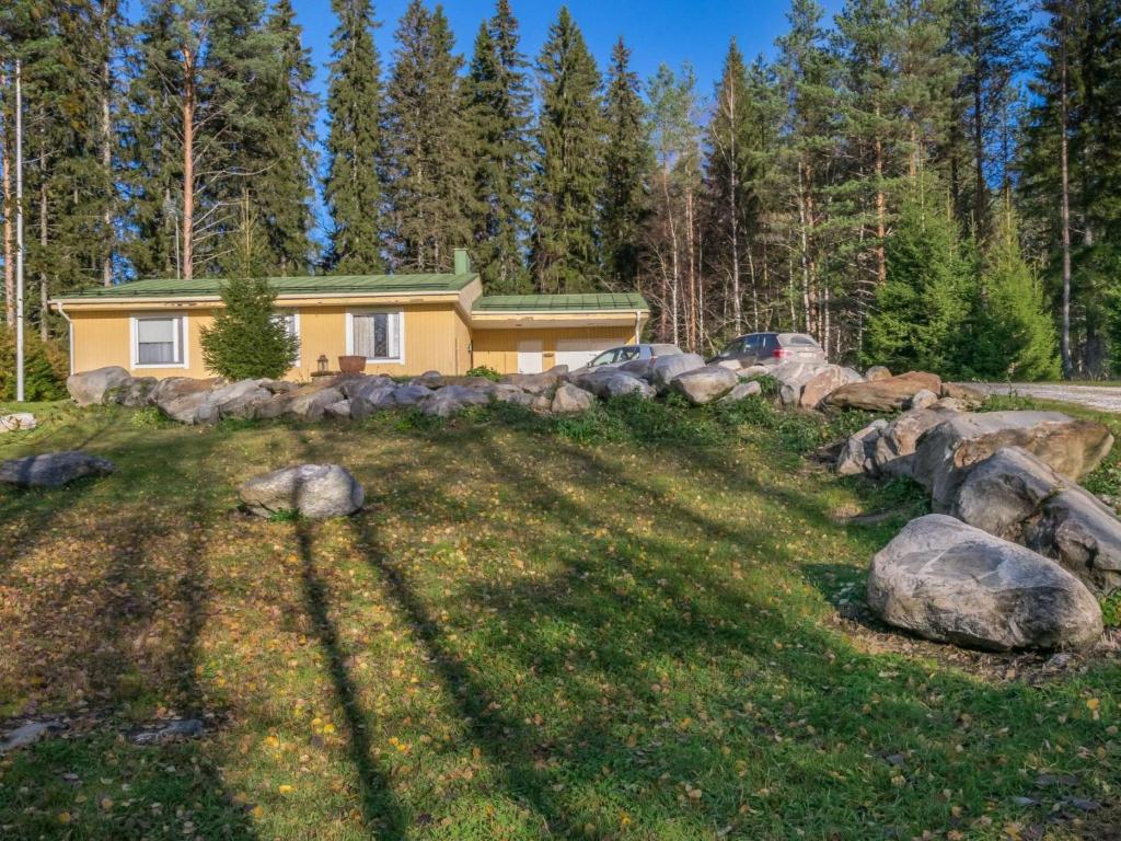 una casa en el bosque con rocas en el patio en Holiday Home Lähtevä by Interhome, en Varistaipale