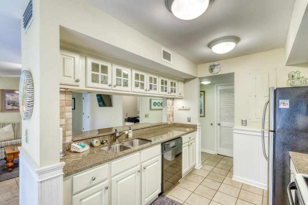 eine Küche mit weißen Schränken, einer Spüle und einem Kühlschrank in der Unterkunft 4849 Turtle Cove Villa in Kiawah Island