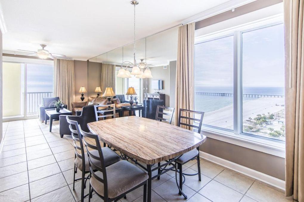 a dining room with a table and chairs and a large window at Grand Panama 1-1201 3-bed in Panama City Beach