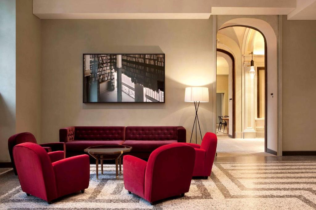 a living room with a couch and chairs and a table at NH Collection Torino Piazza Carlina in Turin