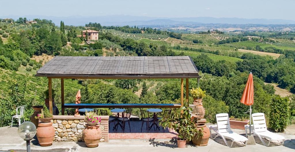 a gazebo with chairs and umbrellas on a hill at B&B I Coppi in San Gimignano