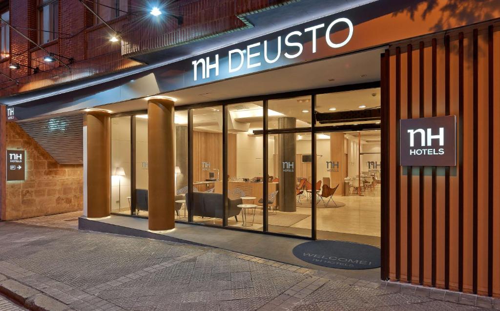 una tienda frente a un edificio con puertas de cristal en NH Bilbao Deusto en Bilbao