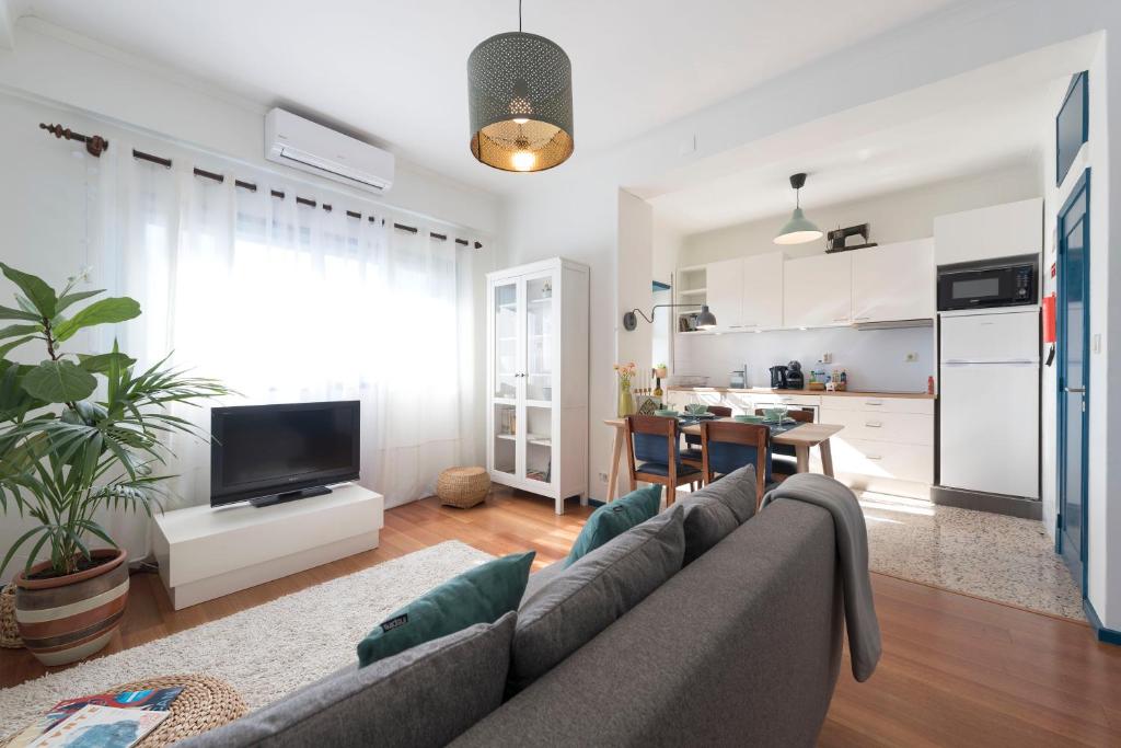 uma sala de estar com um sofá e uma cozinha em All in flat by, city center, skyline no Porto