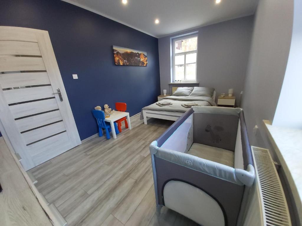 pokój z łóżkiem oraz sypialnia z łóżkiem i łóżkiem w obiekcie Apartament Na Franciszkańskiej w Szklarskiej Porębie