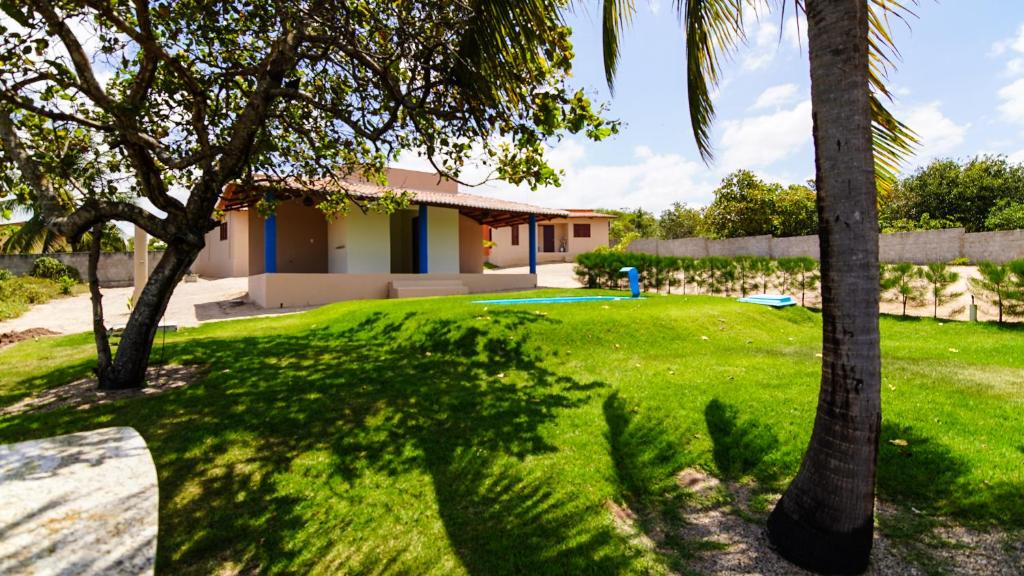 a yard with two palm trees and a house at Village Aquarella in Pipa