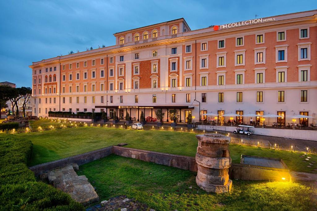 a large building with a lawn in front of it at NH Collection Palazzo Cinquecento in Rome