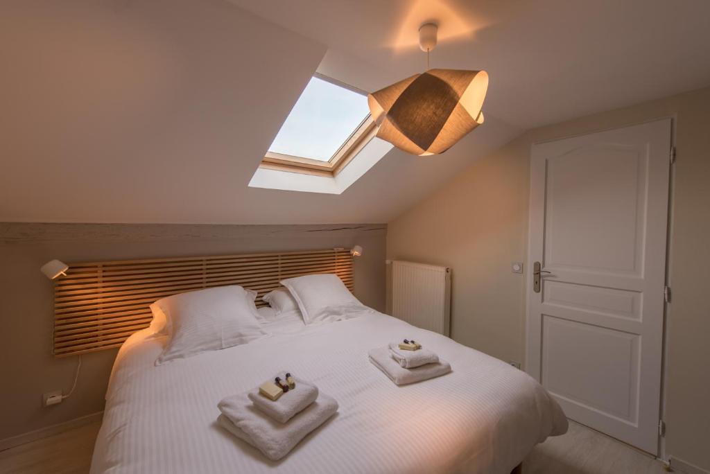 a bedroom with a white bed with towels on it at Maison Loiseau - Maison Calme au Centre de Beaune in Beaune