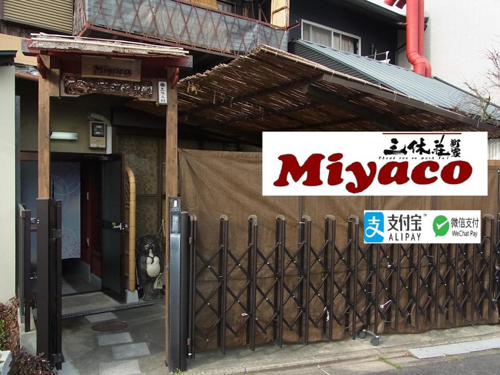una señal frente a un edificio con una puerta en Thank you so muchya Miyaco, en Kioto