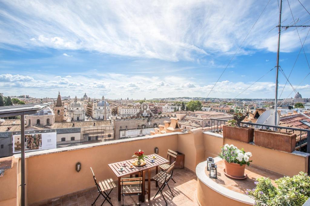 d'un balcon avec une table et des chaises offrant une vue sur la ville. dans l'établissement Roof top magic Piazza del Popolo, à Rome