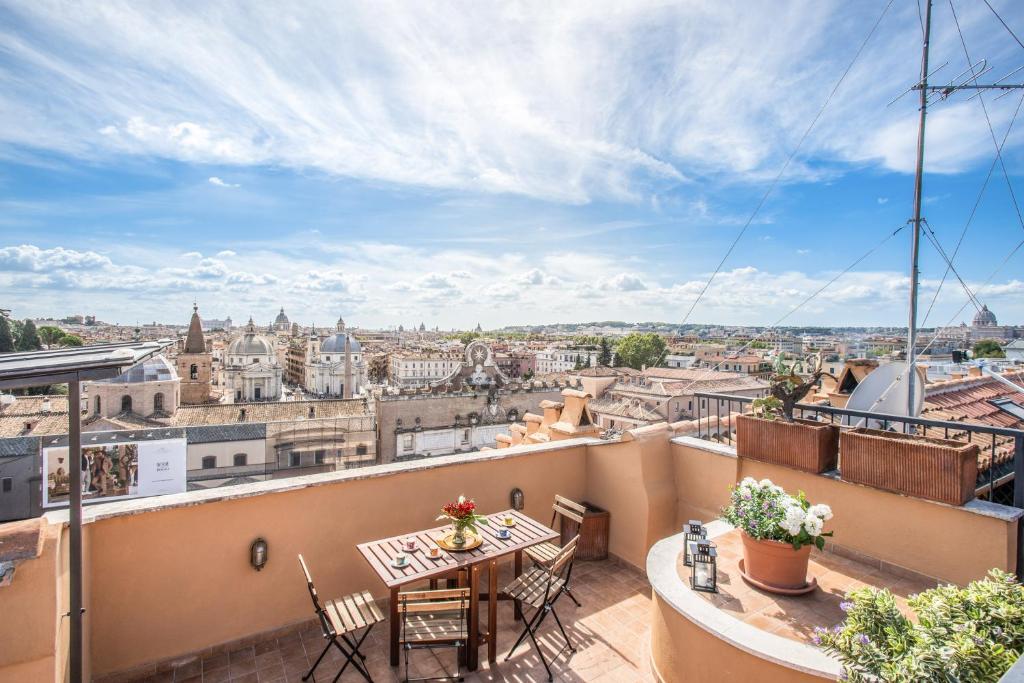 balkon ze stołem i krzesłami oraz widokiem na miasto w obiekcie Roof top magic Piazza del Popolo w Rzymie