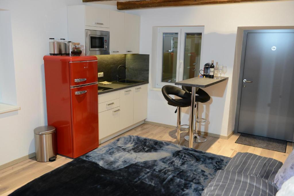 kuchnia z czerwoną lodówką i stołem w pokoju w obiekcie Auszeit Vienna Wellness Apartment w Wiedniu