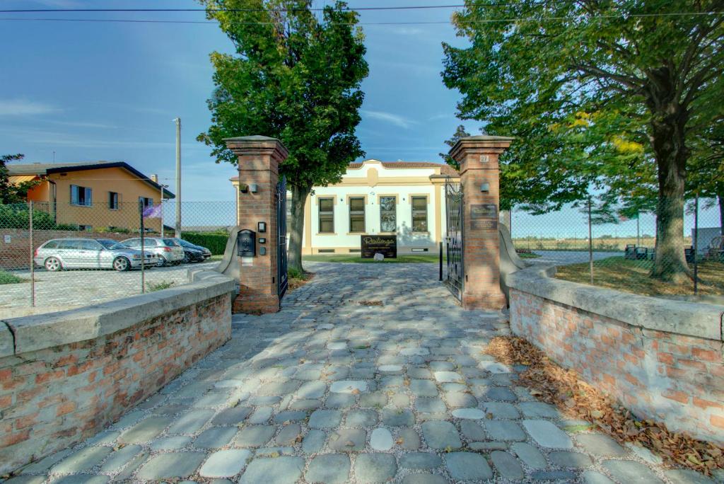 a brick walkway leading to a white house at Resilienza in Mira