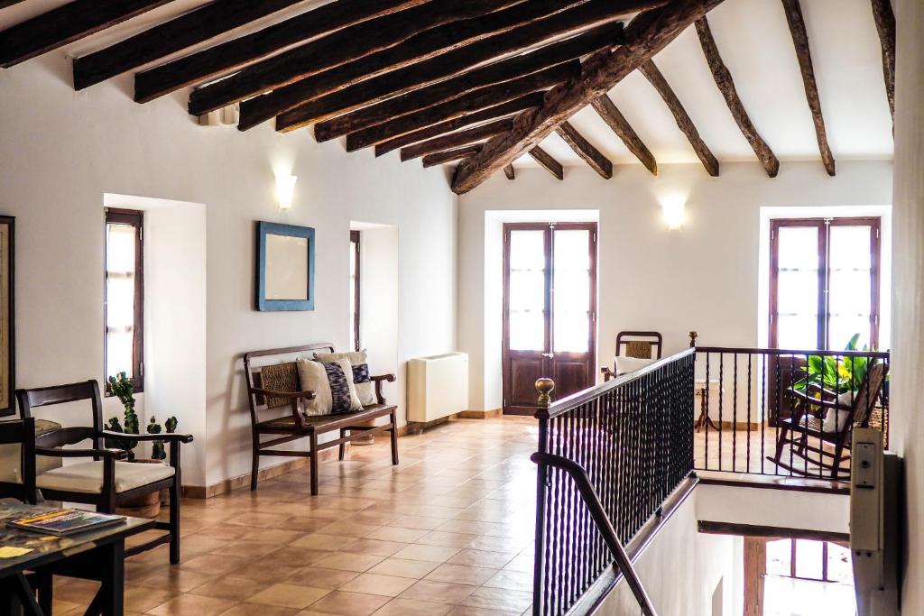 a living room with wooden ceilings and a staircase at Can Font in Sineu