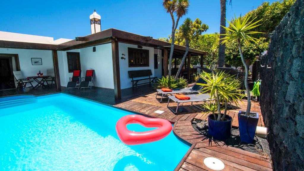una piscina con un flotador rojo junto a una casa en Villa Ana en Costa Teguise
