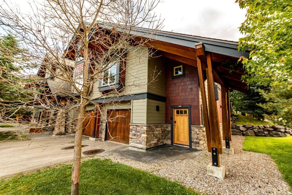 una casa con un árbol delante de ella en Pinnacle Ridge by FantasticStay, en Fernie