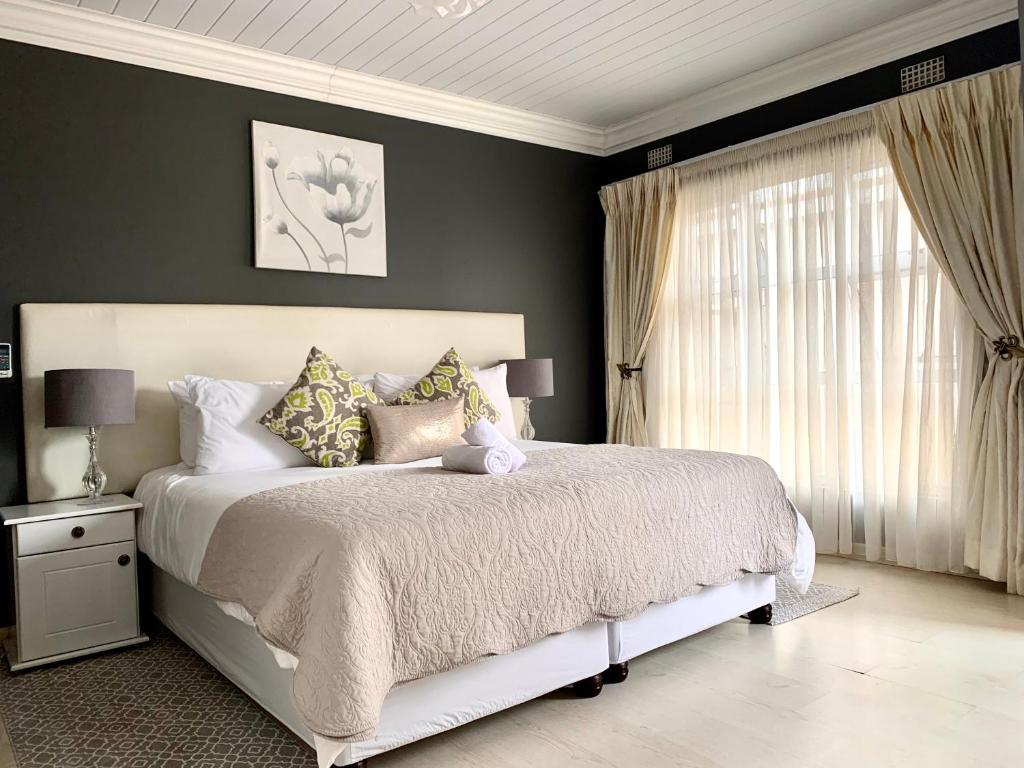 Un dormitorio con una cama grande y una ventana en Resthaven Guest House, en Mthatha
