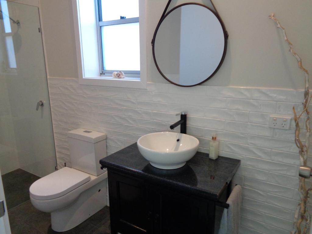 a bathroom with a sink and a toilet and a mirror at Erwins Lagoon Retreat in Beachport
