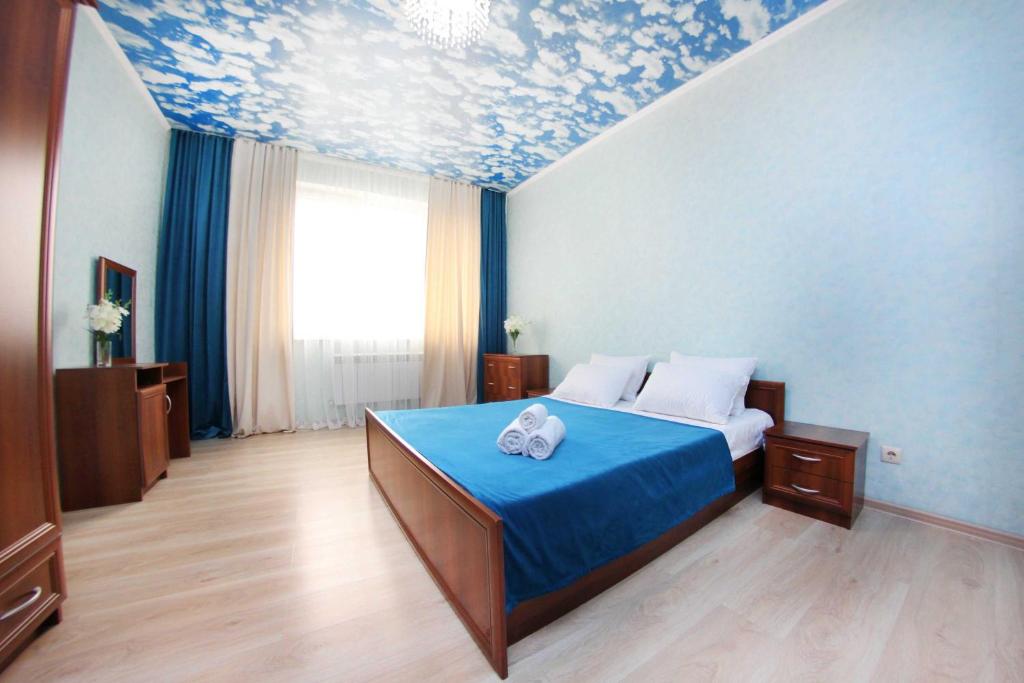 sypialnia z łóżkiem z obrazem na suficie w obiekcie Razmestim в ЖК Айгерим w mieście Ałma-Ata