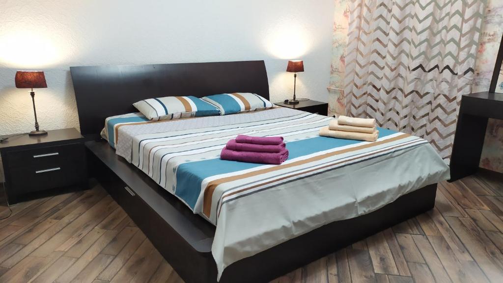 um quarto com uma cama grande com duas toalhas em Podil Apart Kontraktova ploshcha Андріївський узвіз Center em Kiev