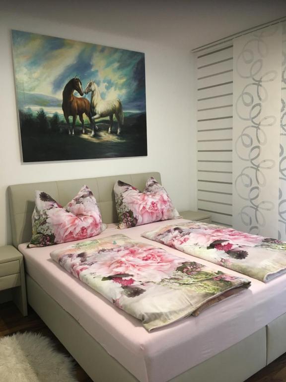 Una cama con una pintura de caballos. en Apartment Elfi, en Leibnitz